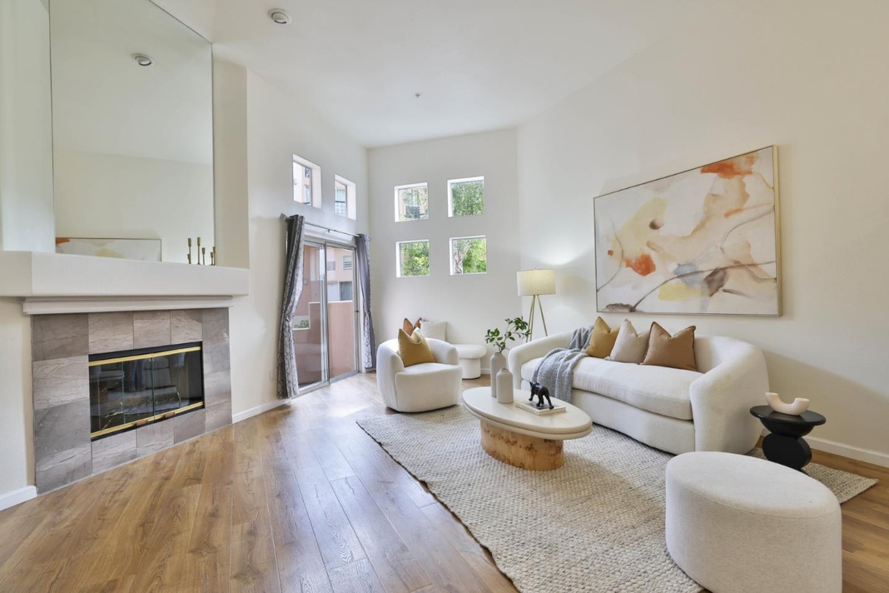 Living room with a stone-tile fireplace, a stacked pair of windows above the mantel, and a sliding glass door out to a private patio